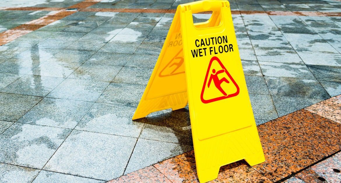 Yellow wet floor warning sign on the floor