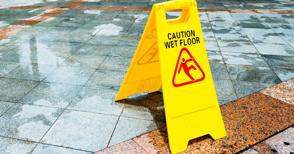 Yellow wet floor warning sign on the floor